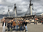 Gruppe von Sprachschülern der Sprachschule Portsmouth beim Besuch eines historischen Segelschiffs im Hafen.