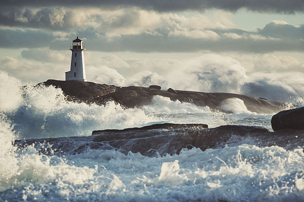 Leuchtturm an stürmischer Küste mit hohen Wellen