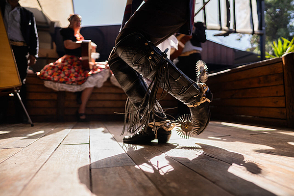 Huaso-Tanz: Stiefel mit Sporen klacken auf Holzbühne.