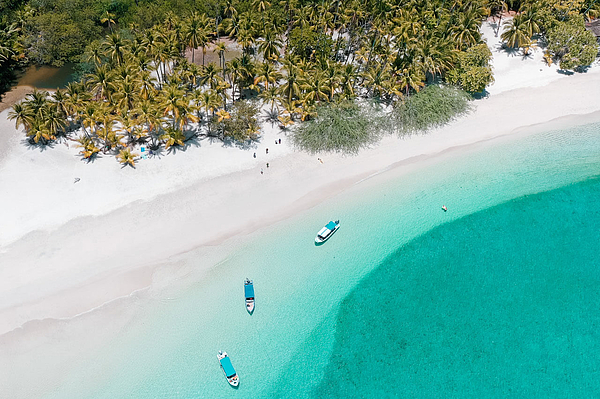 Luftaufnahme weißer Strand mit Palmen und Booten