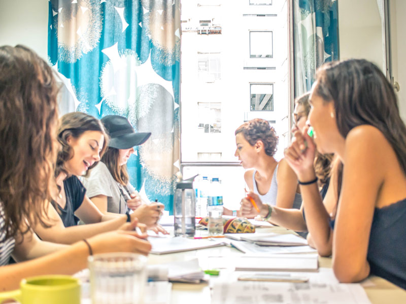 Sprachschülerinnen arbeiten gemeinsam an einer Übung im hellen Klassenzimmer