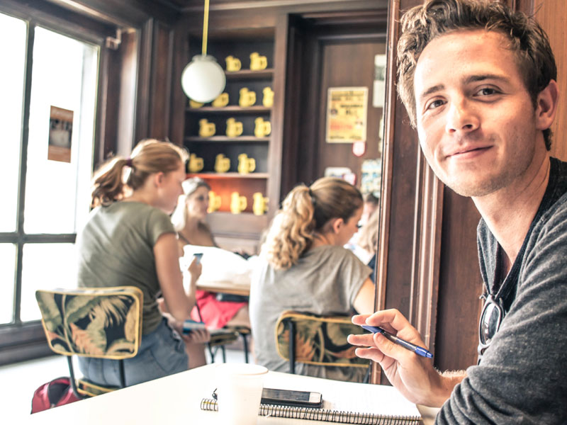 Sprachschüler entspannt beim Spanischlernen im Café-Bereich der Schule