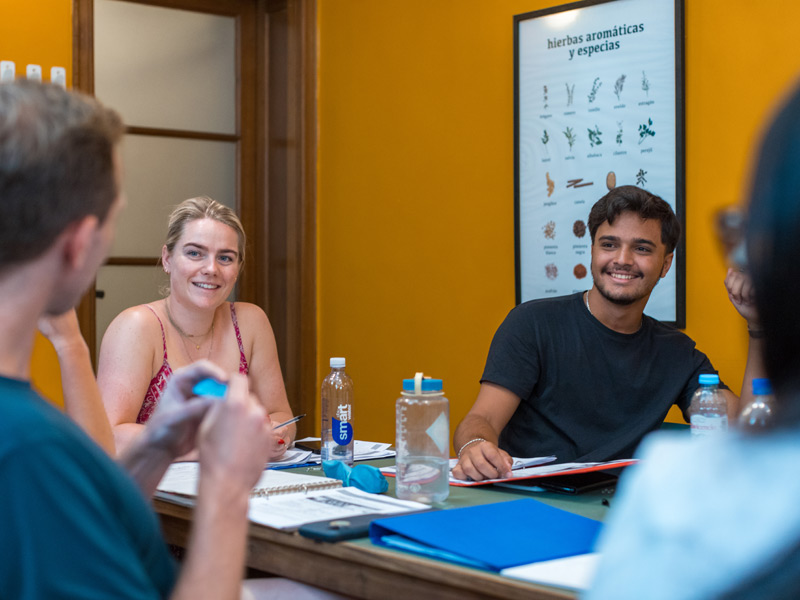 I partecipanti sorridenti si scambiano opinioni durante la lezione di spagnolo alla scuola Expanish Buenos Aires.