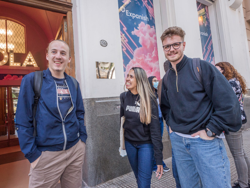 Tre felici studenti di spagnolo davanti all'ingresso della scuola di spagnolo Expanish Buenos Aires