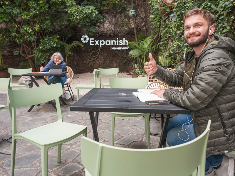 Studenti di spagnolo sorridenti durante la pausa nell'area esterna della scuola Expanish fa il pollice in su