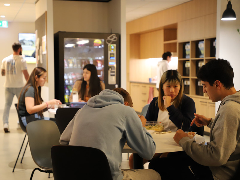 Schülerinnen und Schüler im Pausenbereich der Sprachschule, lernen und essen gemeinsam während ihrer Sprachreise.