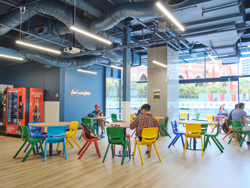 Moderne Aufenthaltslounge der Langports Brisbane mit bunten Sitzmöbeln und großen Fenstern