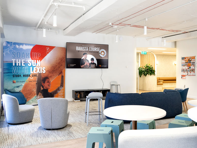 Lounge-Bereich der Sprachschule in Brisbane mit Sitzgelegenheiten und Infos zu Kursen