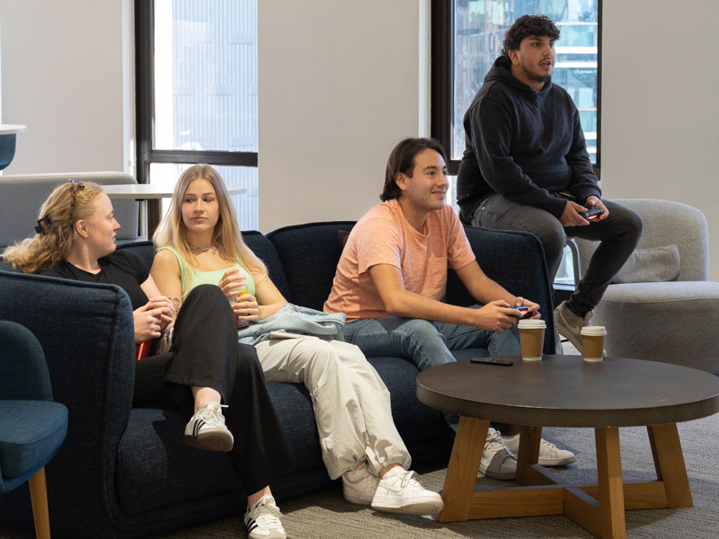 Sprachreiseteilnehmende entspannen gemeinsam im Aufenthaltsraum der Schule