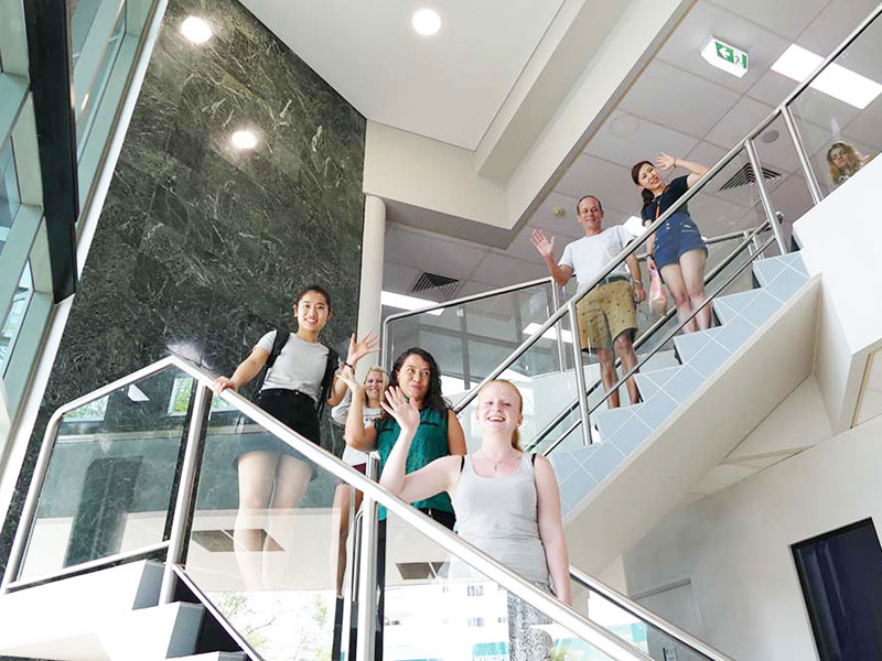 Lernende auf der Treppe der Sprachschule üben Kommunikation und Konversation im Englischkurs