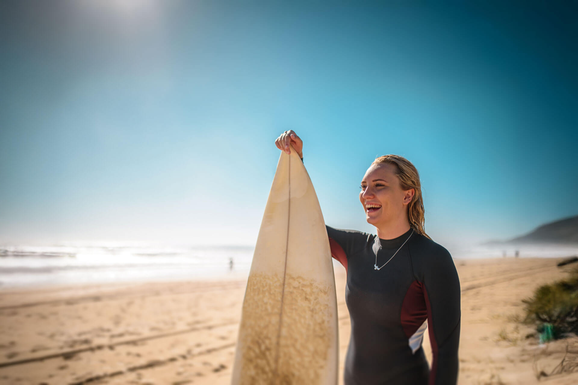 Teilnehmende lächelt am Strand nach Surfkurs und Englisch Sprachtraining im Ausland