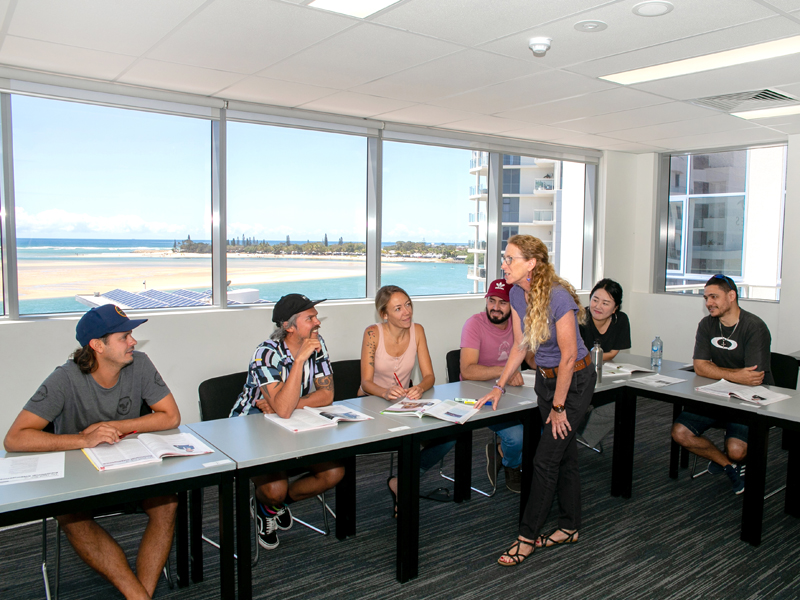 Lehrerin unterrichtet kleine Gruppe mit Meerblick im Sprachkurs