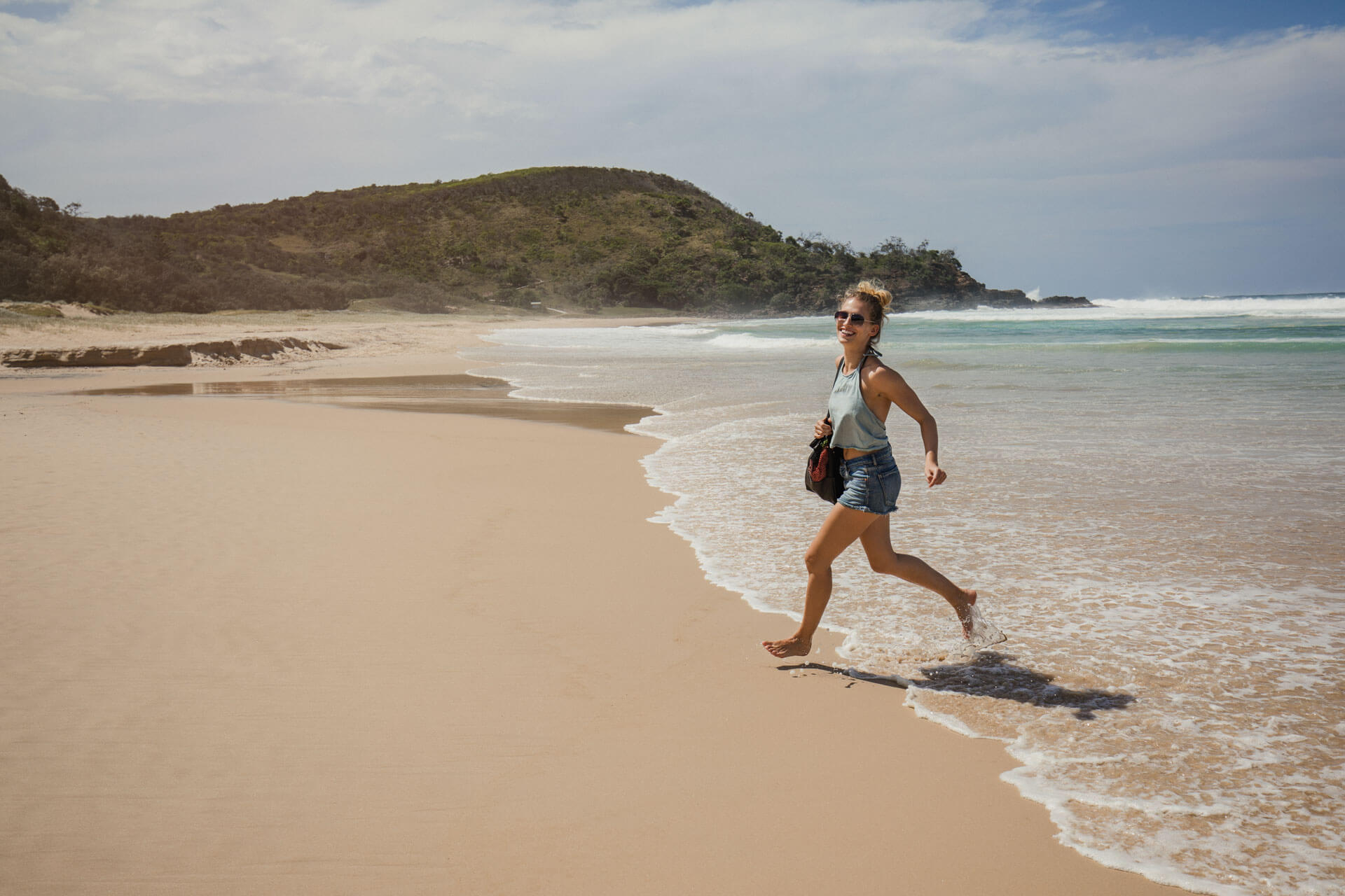 Teilnehmende genießt ihre Englisch Sprachreise am Strand und trainiert Hörverständnis im Alltag