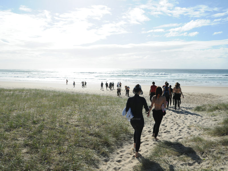 Teilnehmende gehen zum Strand für Freizeitaktivitäten der Sprachreise