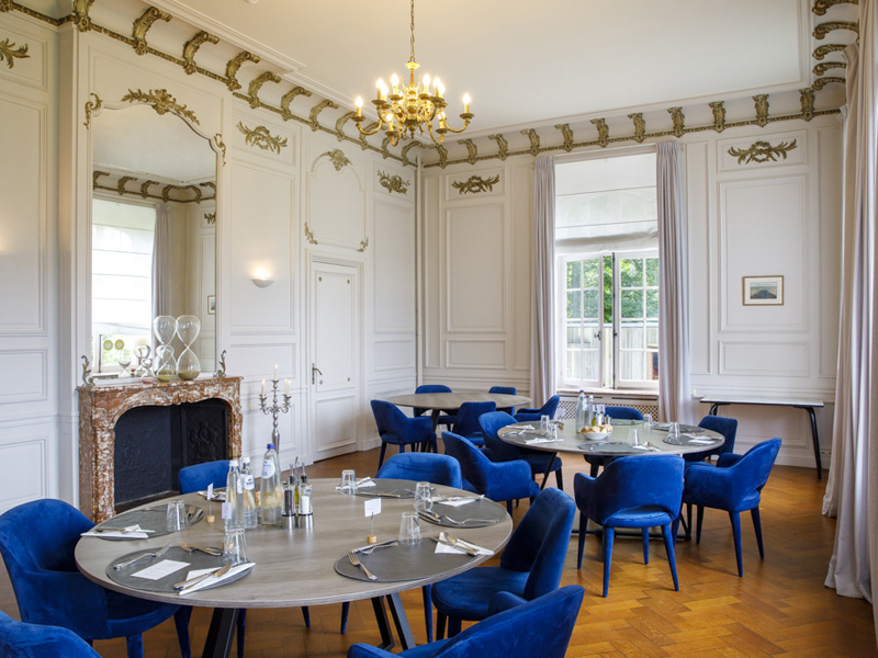 Eleganter Speisesaal mit runden Tischen, in dem Teilnehmende von Business-Sprachreisen ihre Mahlzeiten gemeinsam einnehmen.