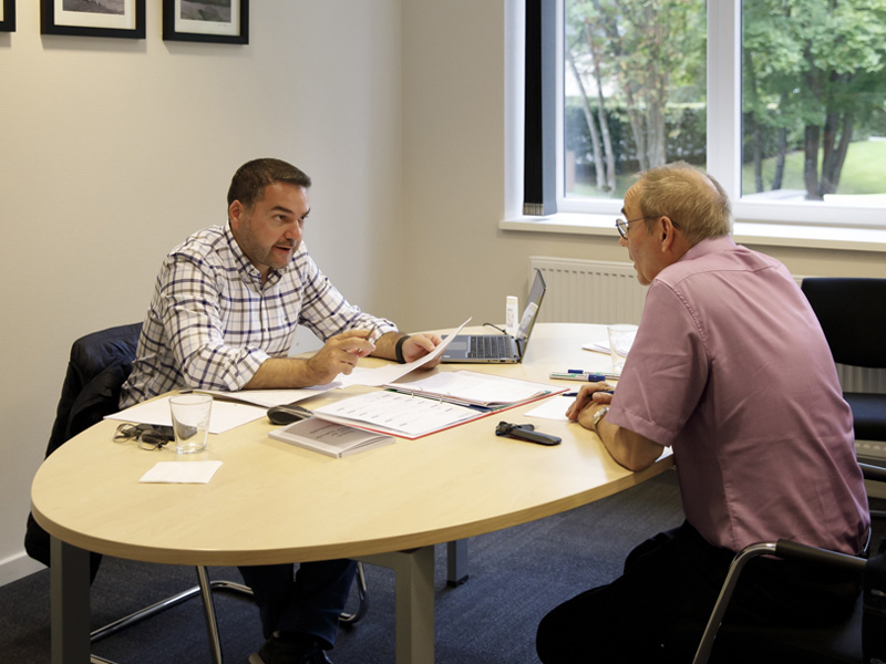 Einzelcoaching im Englischunterricht: Zwei Teilnehmende einer Business-Sprachreise arbeiten konzentriert mit Lernunterlagen.