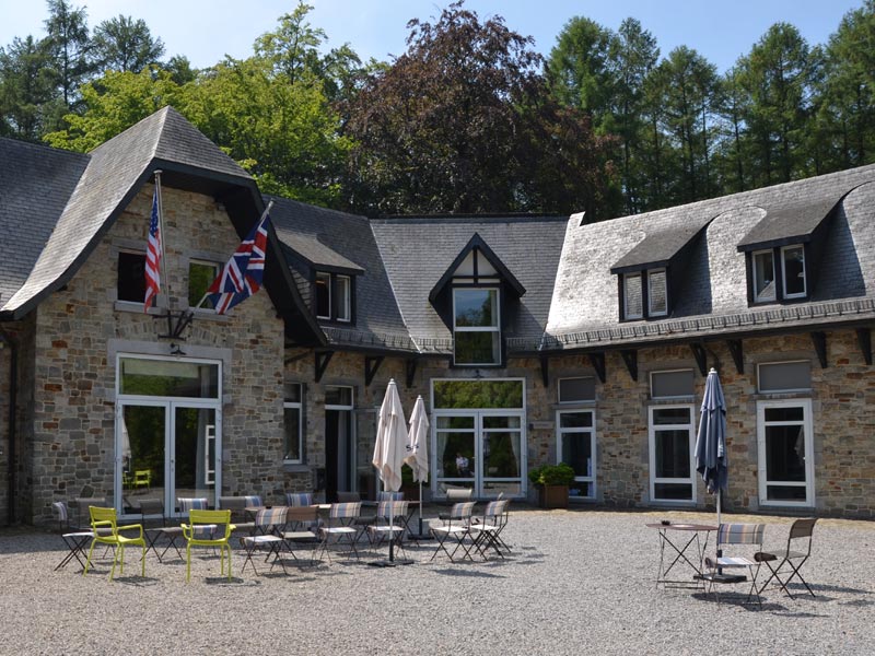 Innenhof der CERAN Sprachschule Spa mit Sitzbereich und Fahnen Großbritanniens und der USA