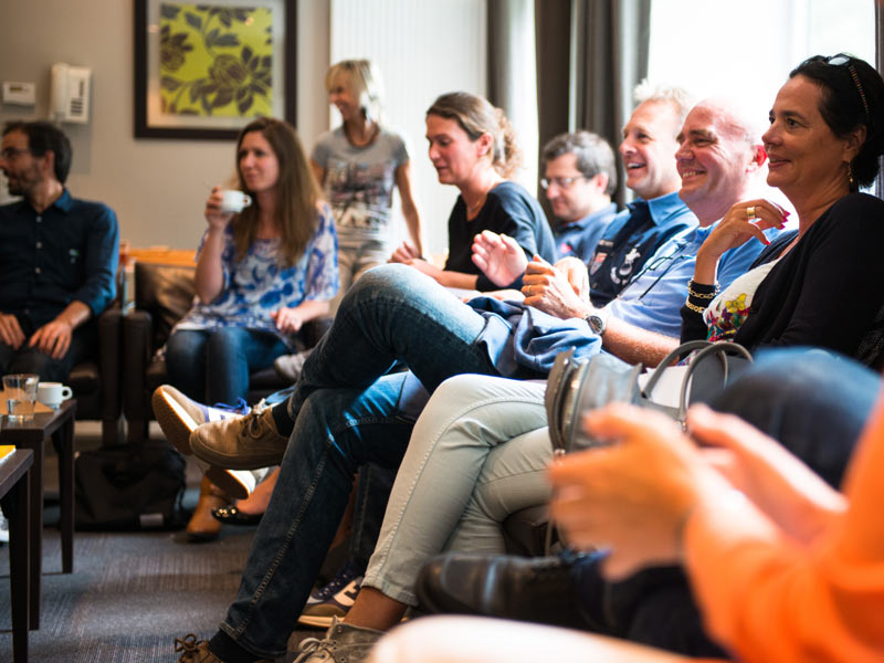Teilnehmende der CERAN Sprachschule Spa sitzen in gemütlicher Runde und tauschen sich aus