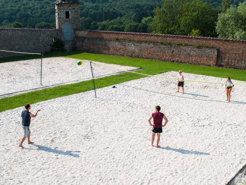 ugendliche spielen Beachvolleyball auf dem Sandplatz des Schulgeländes