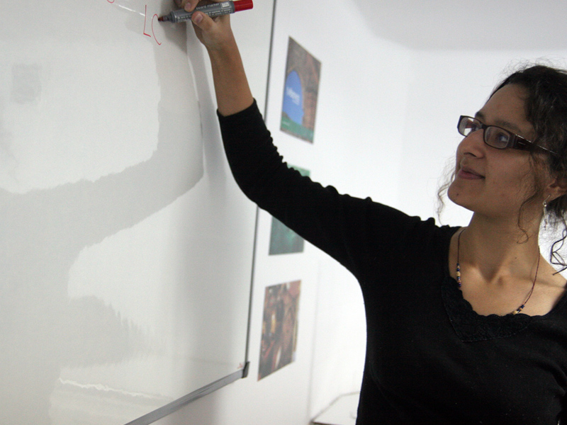 Lehrkraft erklärt Sprachinhalte an der Tafel im Unterricht