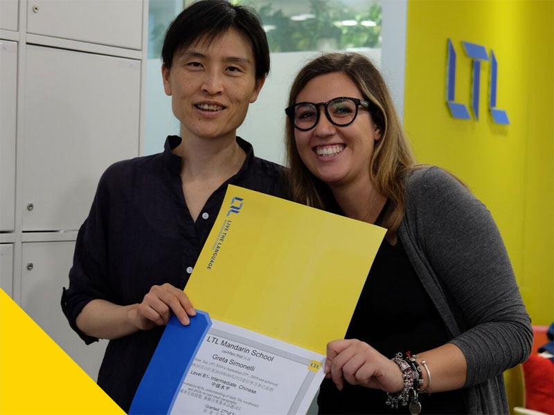 Lehrkraft überreicht Teilnehmerin Zertifikat an der LTL Language School