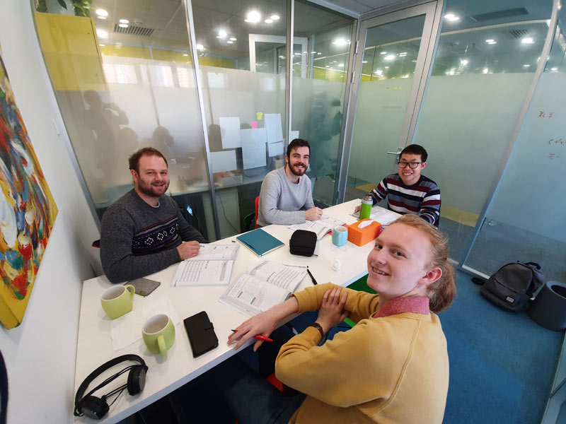 Chinesischkurs in heller Unterrichtskabine mit motivierter Lerngruppe