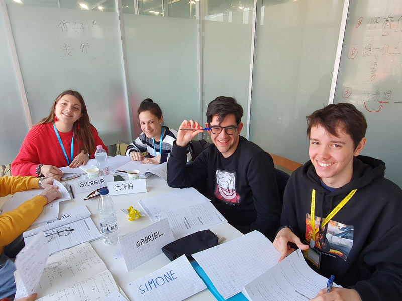 Lernende beim Chinesischunterricht mit Notizen und Kursunterlagen in Peking