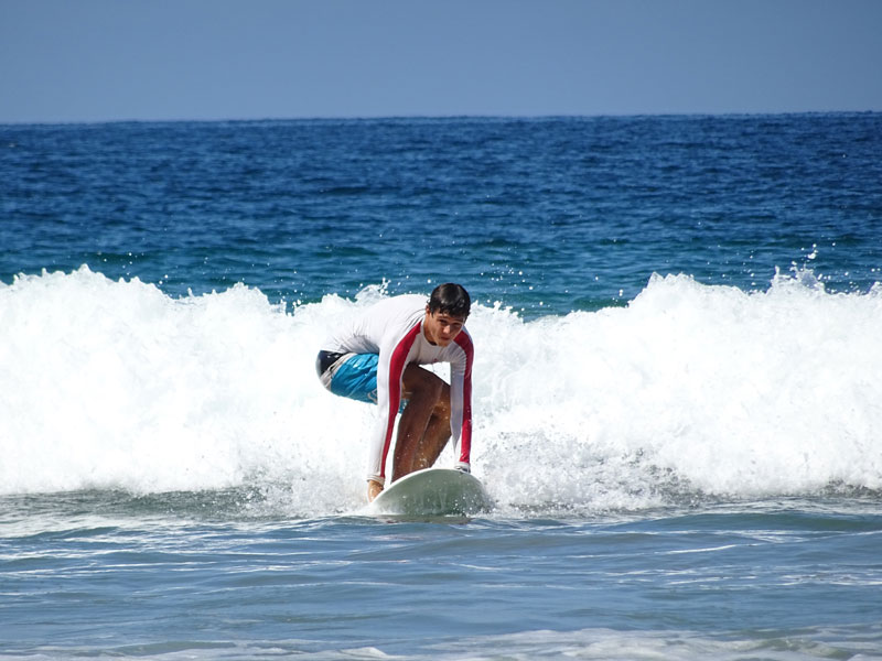 Sprachreisender beim Surfen am Strand von Tamarindo