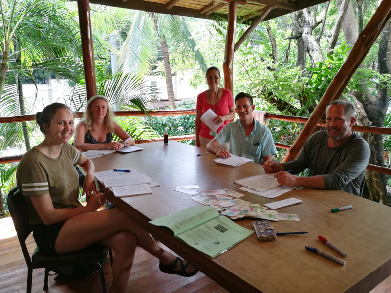 Kleingruppe beim Spanischunterricht im offenen Klassenzimmer mit Naturblick