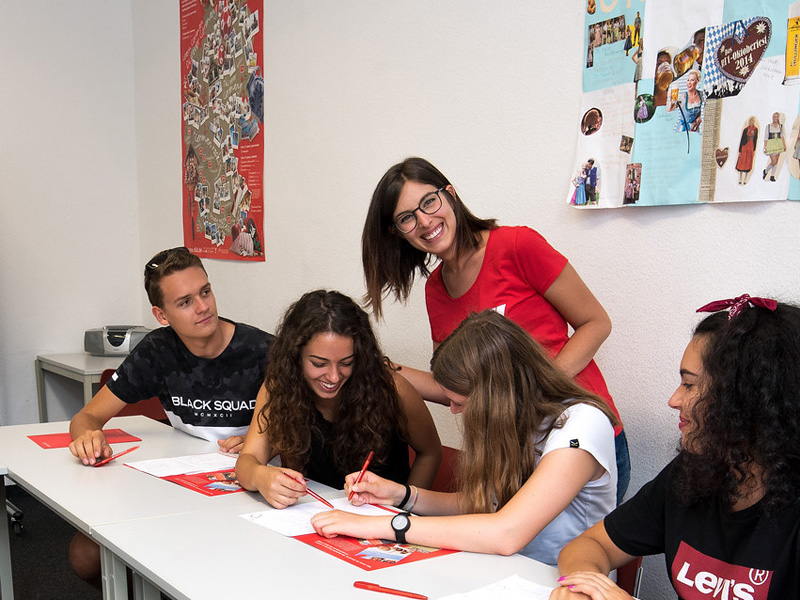 Lehrerin begleitet Jugendliche bei einer Sprachübung im Unterricht in Augsburg