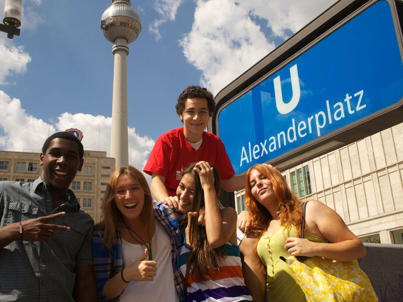 Gruppe internationaler Sprachschüler am Alexanderplatz, unterwegs auf einem Ausflug während ihrer Deutsch-Sprachreise.