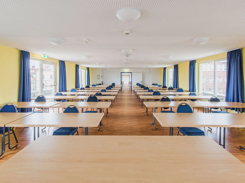 Heller Unterrichtsraum mit mehreren Tischreihen und Fenstern im did deutsch institut Berlin