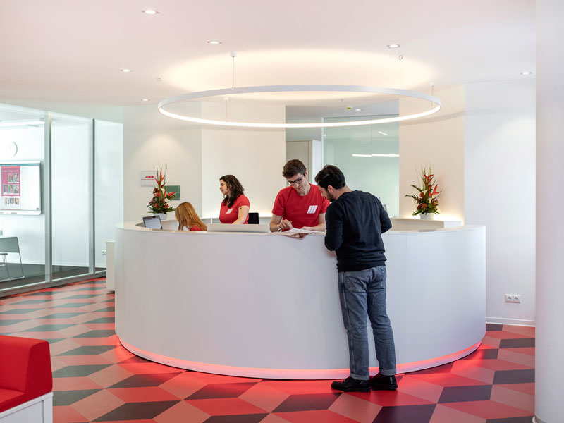 Empfangsbereich des did deutsch-instituts Berlin mit moderner weiß-roter Einrichtung