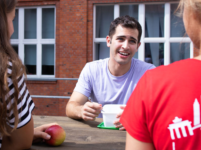 Sprachschüler unterhalten sich in der Pause im Innenhof des did deutsch-instituts