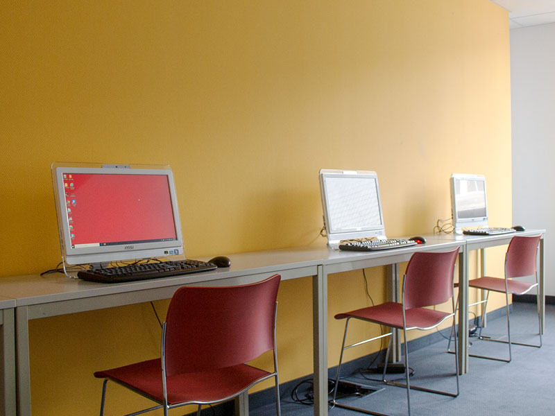 Arbeitsbereich mit Computerplätzen und gelber Wand im did deutsch institut Frankfurt