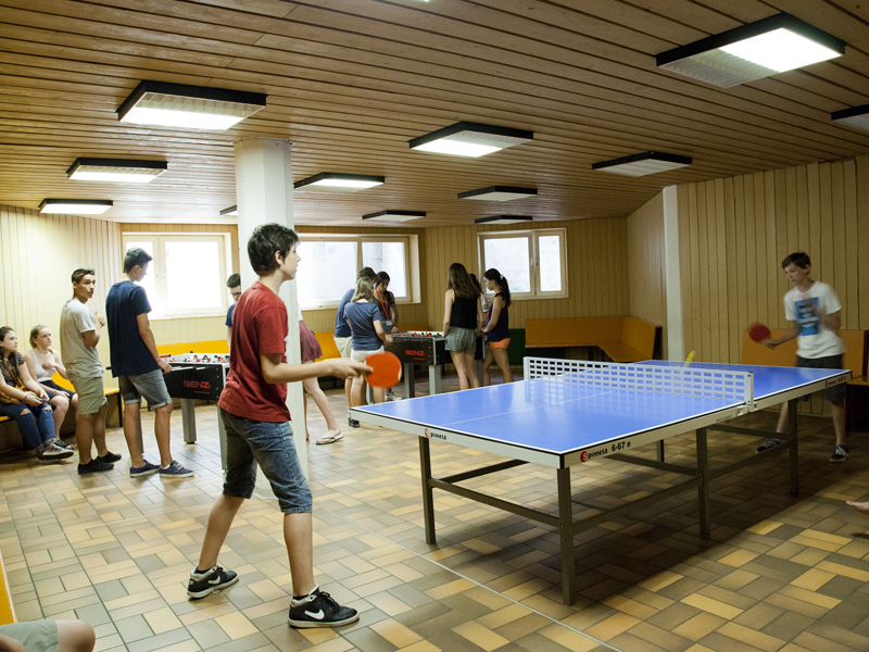 Freizeitraum mit Tischtennisplatte und Kickertischen, wo Jugendliche gemeinsam spielen