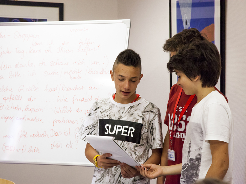 Drei Jugendliche präsentieren ihre Übung vor der Klasse