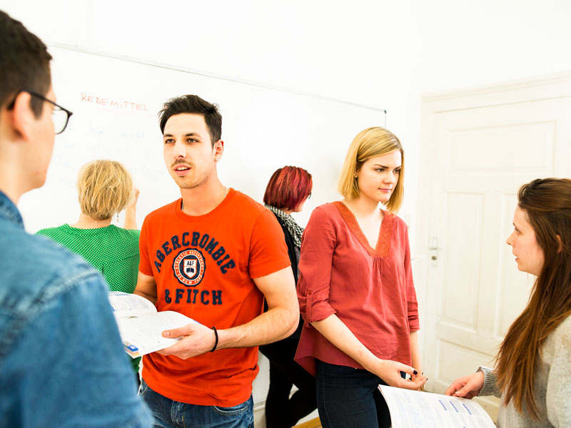 Kleine Lerngruppe übt Sprachdialoge im Unterricht