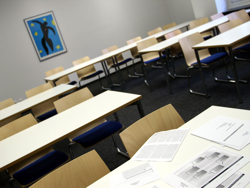 Moderner Klassenraum mit hellen Möbeln und blauer Wanddekoration