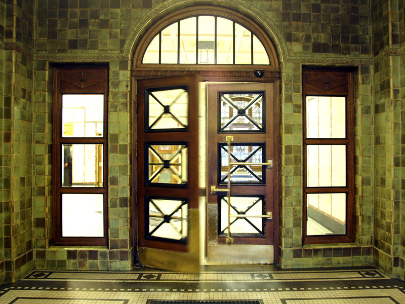 Eingangsbereich mit verglaster Tür und grünen Fliesen