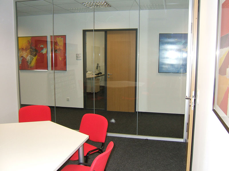 Besprechungsraum mit roten Stühlen und Glaswand