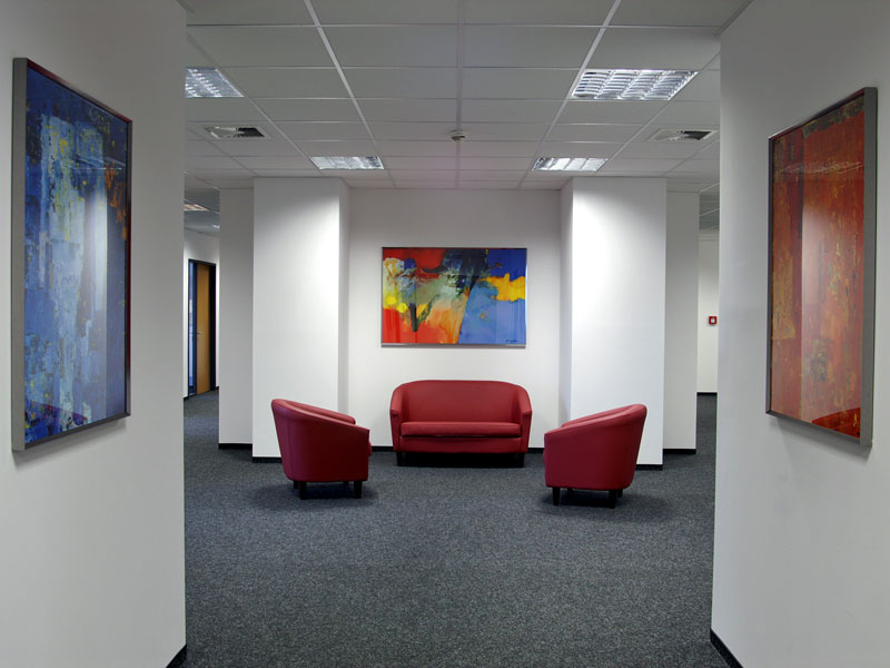 Loungebereich mit roten Ledersesseln und moderner Kunst an den Wänden