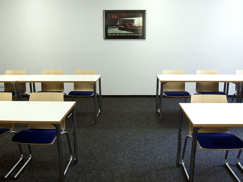 Kleiner Unterrichtsraum mit hellen Möbeln und stilvollem Wandbild