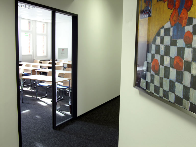 Flur mit Blick in ein Klassenzimmer und moderner Wanddekoration