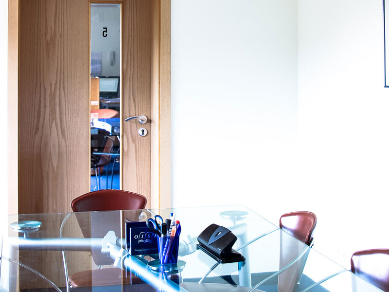 Seminarraum der OISE Sprachschule Heidelberg mit Glastisch und Zugang zu weiteren Kursräumen 