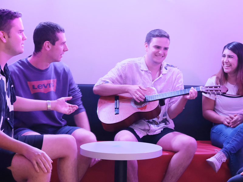 Gruppe von Sprachschülerinnen und Sprachschülern musiziert und singt gemeinsam in der Freizeit