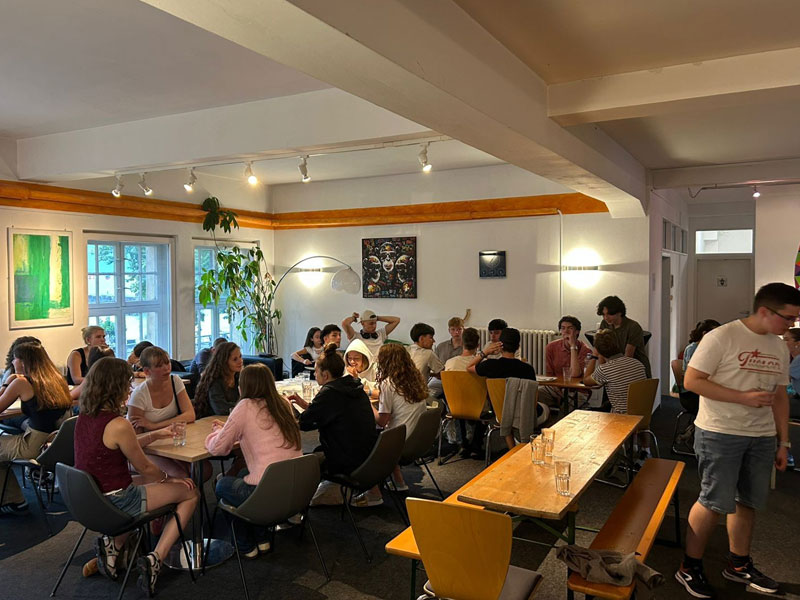 Jugendliche sitzen gemeinsam in einem Aufenthaltsraum der Schule und unterhalten sich
