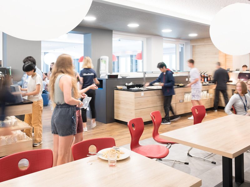 Helle und moderne Mensa des Humboldt-Instituts Lindenberg mit Jugendlichen beim Essen und Austauschen