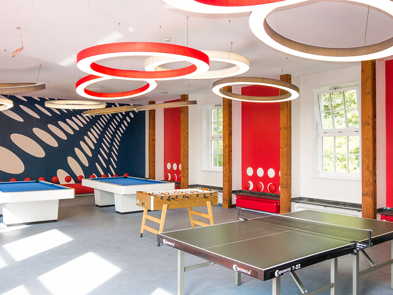 Freizeitraum mit Tischtennisplatte, Billardtischen und bunter Wandgestaltung im Humboldt-Institut Lindenberg