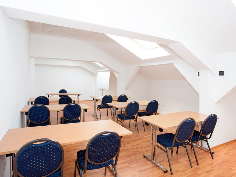 Weitere Unterrichtsräume mit Tischen und Stühlen unter Dachfenstern im did deutsch-institut München